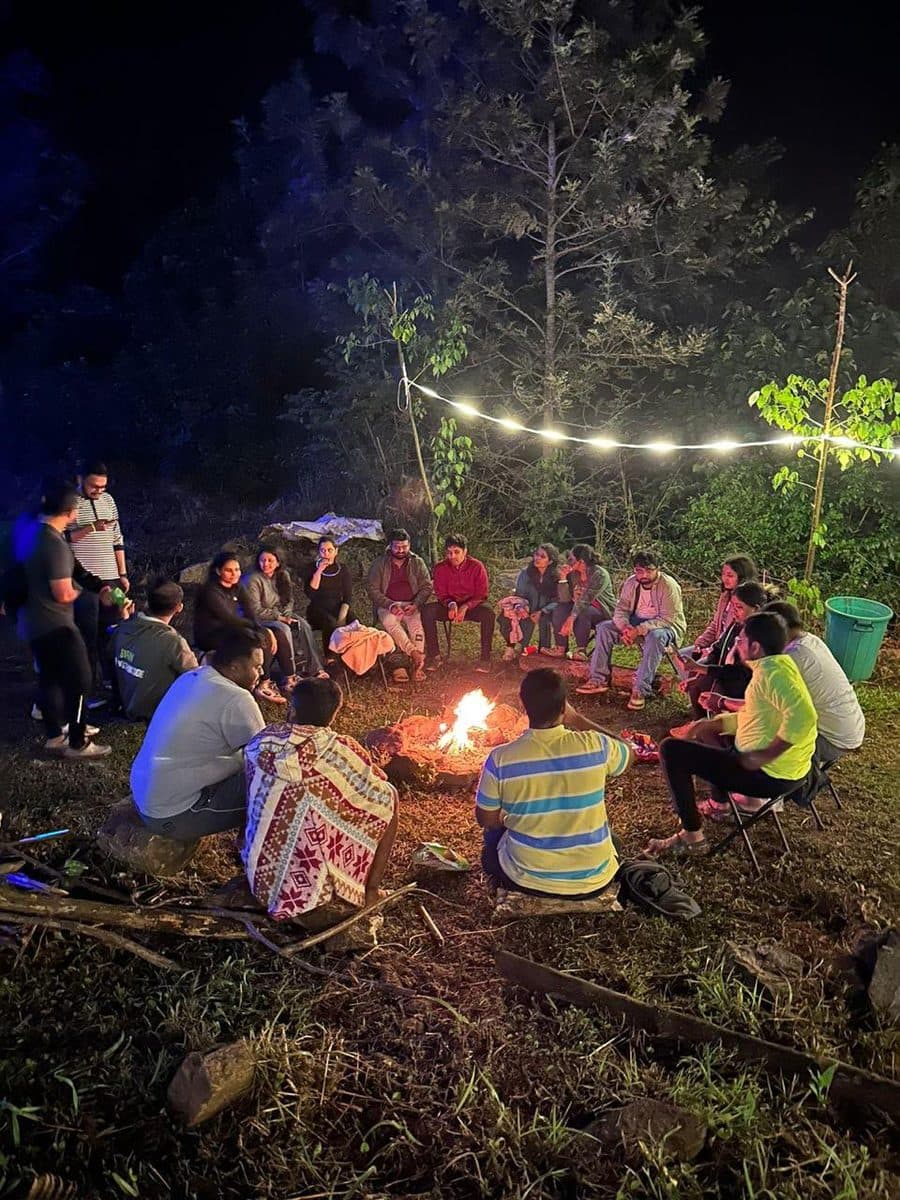 Riders sitting in a circle around the fire at night